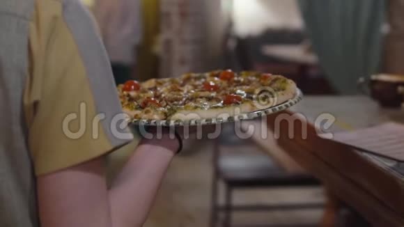 服务员给顾客端了一个美味可口的圆形披萨视频的预览图