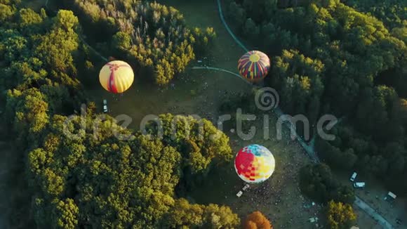 节日期间公园内三个热气球的鸟瞰图美丽的天空和日落视频的预览图