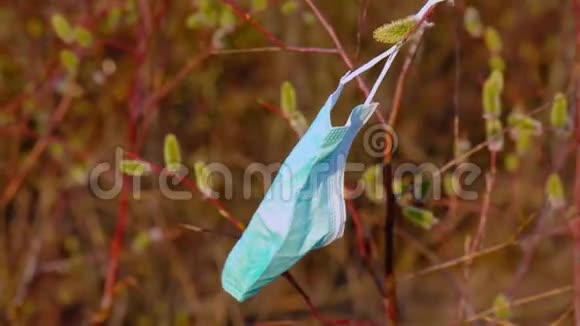 医用口罩挂在森林露天的柳枝上春风早春视频的预览图