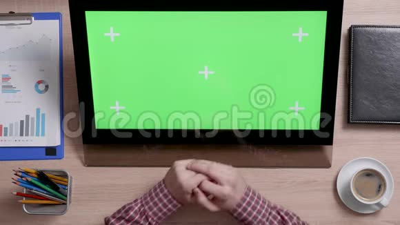 男人触摸显示器上的绿色屏幕左上角视频的预览图