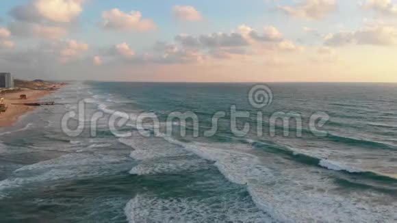 日落时分鸟瞰特拉维夫的海滩和长廊休息的人和冲浪者乘坐地中海的波浪视频的预览图