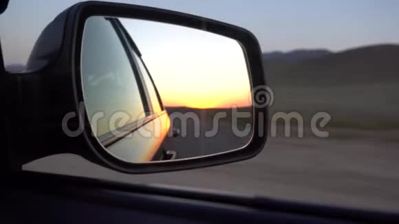 汽车的侧镜在速度观橙色黎明草原公路和青山视频的预览图