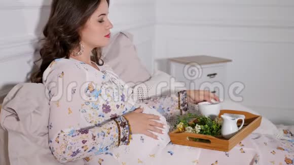 放松孕妇在床上喝健康茶视频的预览图