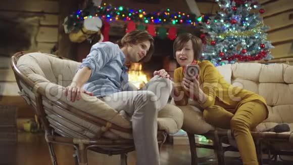 在圣诞夜看智能手机照片的男女青年视频的预览图