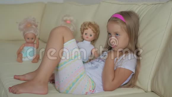 那个女孩坐在客厅的沙发上拿着洋娃娃视频的预览图