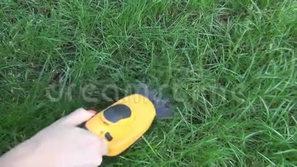 女人在空地上处理一块绿色的草坪上面有一个带有黄色身体的电动修剪器有一个长牙嘴视频的预览图