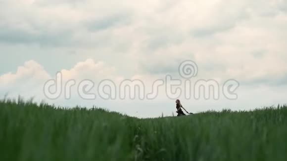 穿着黑色衣服的女孩跑过田野金发的浪漫形象视频的预览图