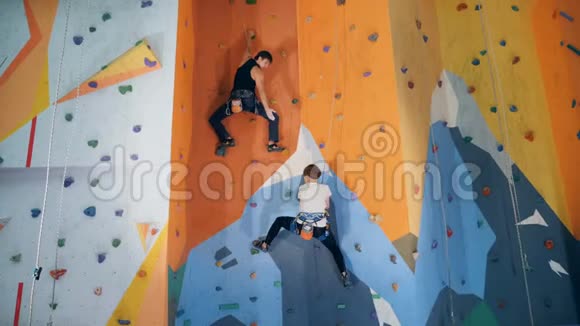 两个人正在攀登一道人工训练墙视频的预览图