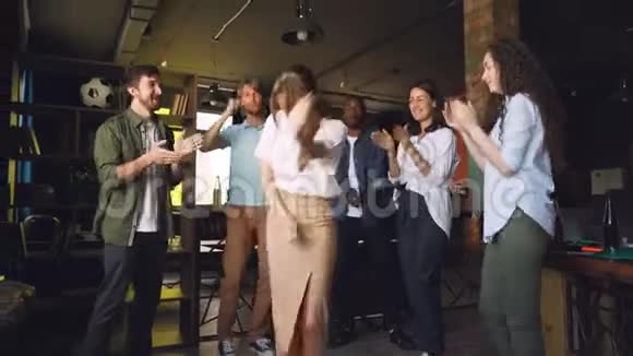 公司员工在现代阁楼式办公室的公司聚会上跳舞有魅力的年轻男女正在视频的预览图