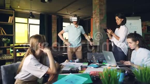 办公室工作人员正在玩虚拟现实眼镜男人戴着他们玩跑步和跳跃游戏视频的预览图