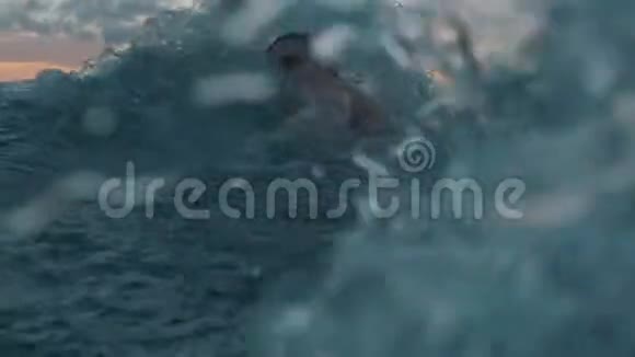 专业游泳运动员在日落时在室外游泳前景视频的预览图
