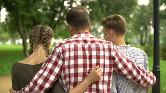 成年父亲与女儿和儿子在公园散步拥抱和交谈家庭视频的预览图