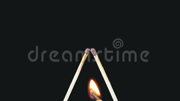 字母L形状的两根火柴在黑色背景下点燃和燃烧视频的预览图