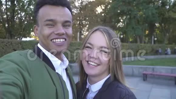 微笑的青少年跨种族夫妇拍摄自己的镜头视频的预览图