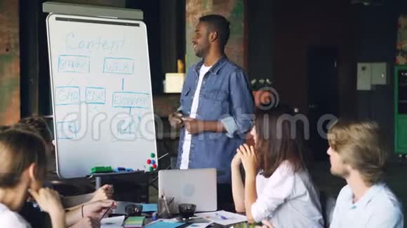 非洲裔美国男子公司的员工在白板上做演讲然后在人们嘲笑和跳舞视频的预览图