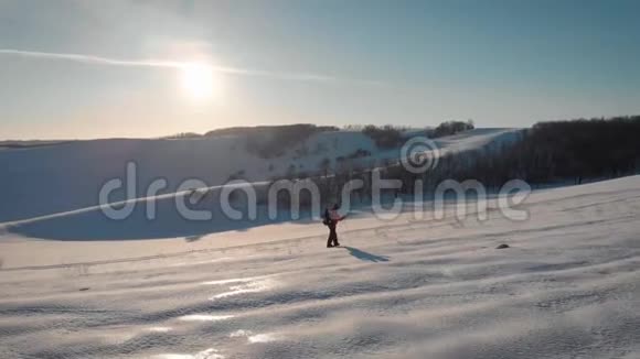 在美丽的冬季日落时分年轻人在雪山上徒步旅行带着长途跋涉的男性登山者视频的预览图