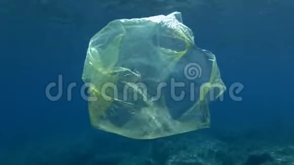 塑料污染蓝色水中黄色塑料袋慢动作丢弃的塑料袋在水面下慢慢漂流视频的预览图