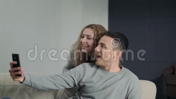 一对情侣在智能手机摄像头上自拍在家里占有和微笑视频的预览图