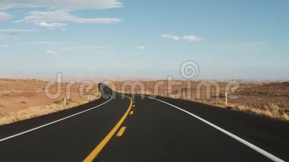 乘坐黑色沥青和黄色线行驶在路上从汽车可以看到沙漠景色视频的预览图