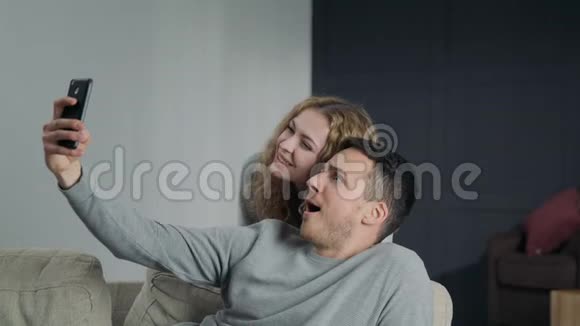 一对情侣在智能手机摄像头上自拍在家里占有和微笑视频的预览图