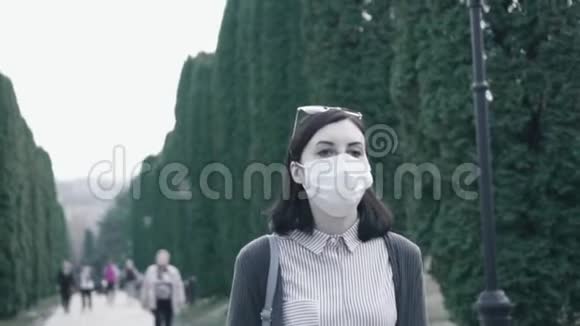 女孩从脸上摘下医用口罩深深地吸入公园里的空气慢点视频的预览图