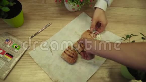 学生们手拿一个三明治切成三块放在桌子上视频的预览图