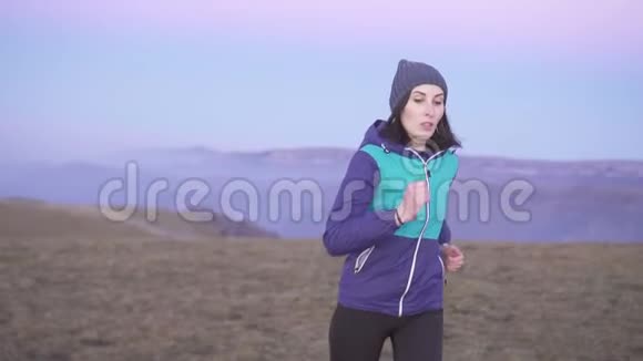 女运动员在日落时分在山上奔跑的肖像慢悠悠视频的预览图