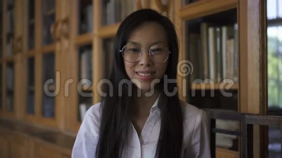 年轻的美女生物学家站在图书馆里摆出一副好心情视频的预览图