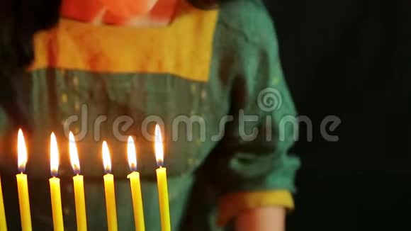 一个女人吹着燃烧的蜡烛把它们熄灭视频的预览图