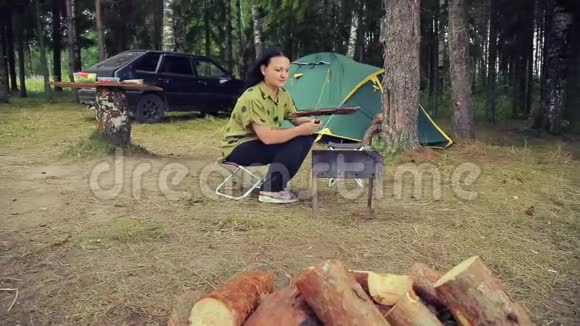 帐篷附近的一个女人用鱼把烤架倒过来摄像机移动视频的预览图