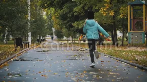 雨天在秋天公园散步的漂亮女孩视频的预览图