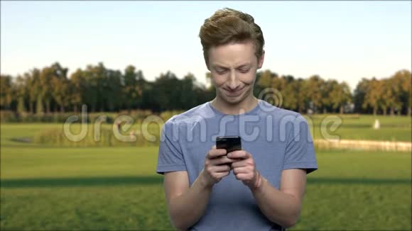 青少年男孩使用智能手机户外视频的预览图
