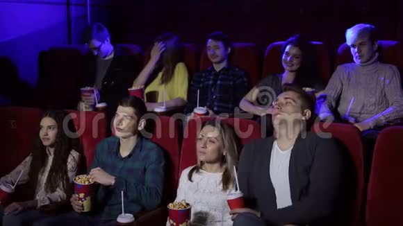 年轻人坐在电影院看电影吃爆米花视频的预览图