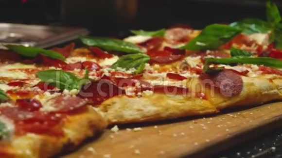 配上罗勒叶的意大利辣香肠披萨框架意大利餐厅或视频的预览图