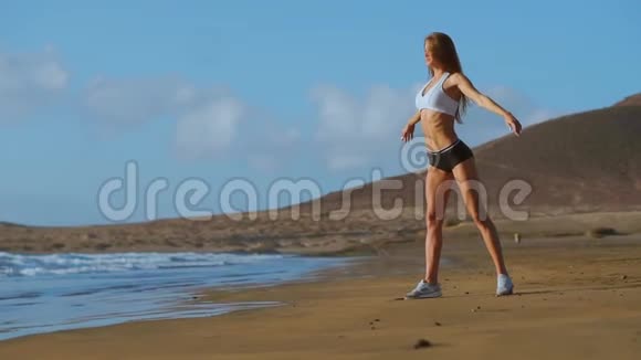 瑜伽女人在海滩上摆姿势在日出时在海滩上锻炼和放松女瑜伽女孩参加训练视频的预览图