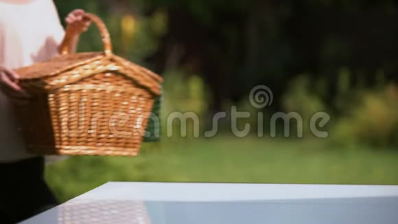 女士把野餐篮放在桌上准备户外家庭晚餐视频的预览图