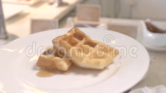 在比利时华夫饼上加入焦糖糖浆传统早晨提供带蜂蜜的甜烤华夫饼视频的预览图