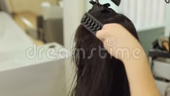 用吹风机和梳子特写美容院的发型视频的预览图
