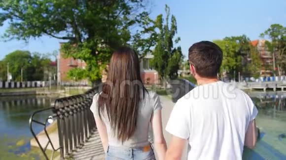 靠近美丽迷人的年轻夫妇在公园散步的后景后方户外活动中弹视频的预览图