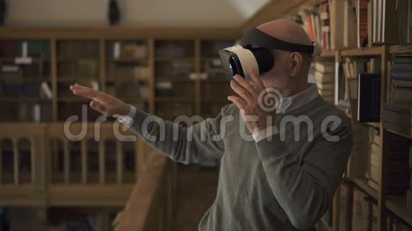 成熟的男人正在测试虚拟现实眼镜站在老式图书馆视频的预览图