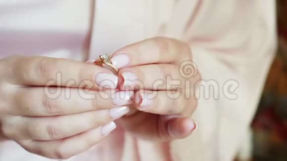 女孩拿着一枚镶有钻石的金戒指视频的预览图