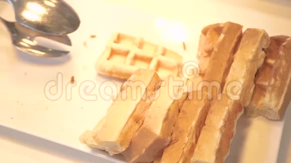 手拿比利时华夫饼躺在酒店餐厅的自助餐白盘子上早上提供甜烤华夫饼视频的预览图