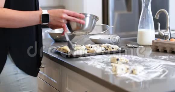 女人在厨房的饼干面团上刷油视频的预览图
