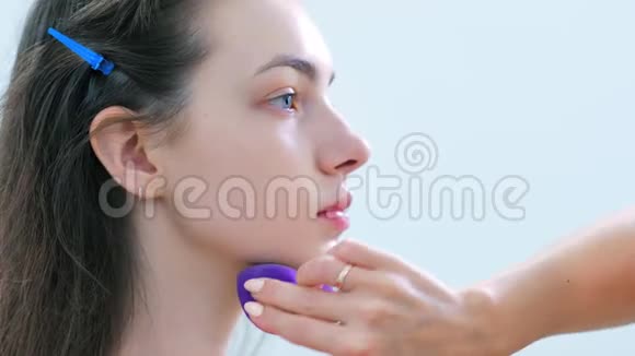 专业化妆师用海绵涂抹色调奶油或补救视频的预览图