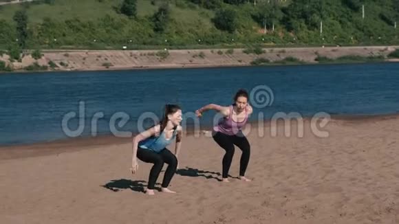 两个女人在城市的河岸上做运动从坐姿跳下来视频的预览图