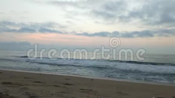 浪漫的日出在热带海滩上有红色的金色光芒海浪与浪漫的日落与海浪海浪视频的预览图
