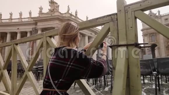 在梵蒂冈的圣彼得大教堂一位女士正站在栅栏后面拍摄一张照片慢动作稳定视频的预览图