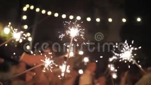 人们在黑夜庆祝节日燃放烟花朋友们在一起玩得很开心慢动作视频的预览图