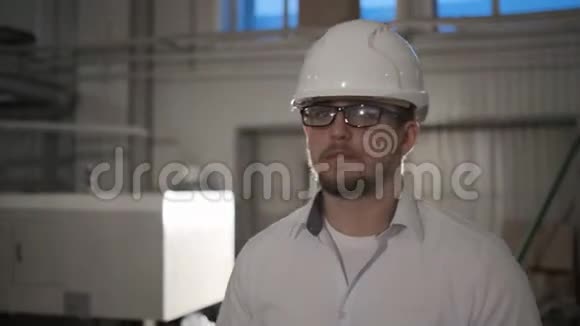 戴着安全帽的工程师正带着平板电脑穿过一家重工业工厂慢动作视频的预览图