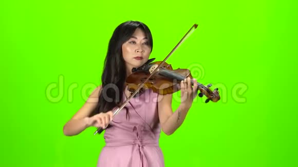 亚洲的女人拉小提琴绿色屏幕视频的预览图